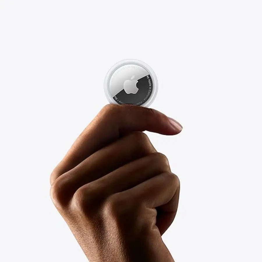 Mano sosteniendo un AirTag de Apple listo para su configuración, mostrando su diseño compacto y elegante.